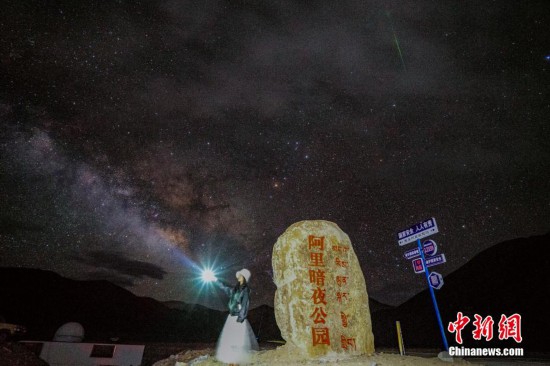 圖為6月20日晚，游客“打卡”西藏阿里暗夜公園，天上是銀河與流星（右上角）。曹枝清 攝