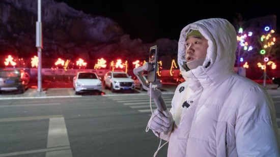 在吉林市阿什哈達(dá)霧凇觀景帶，霧凇播報(bào)員正在直播。新華社記者 李典 攝