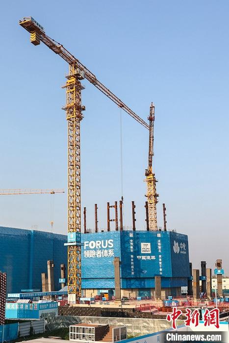 從完成頂層設(shè)計(jì)到如火如荼大規(guī)模建設(shè)，六年來(lái)，雄安新區(qū)如春天的竹子一般拔節(jié)生長(zhǎng)，這座承載千年大計(jì)的“未來(lái)之城”已雄姿初顯。從“一張白紙”開(kāi)始著墨，如今的雄安新區(qū)已是濃墨重彩的“山水畫(huà)”。<a target='_blank' href='/'>中新社</a>記者近日走訪了雄安新區(qū)多地，從“藍(lán)綠金”三色感受這座“未來(lái)之城”的巨大變化。圖為7月19日，河北雄安新區(qū)，中國(guó)中化總部基地項(xiàng)目施工現(xiàn)場(chǎng)。 <a target='_blank' href='/'>中新社</a>記者 易海菲 攝