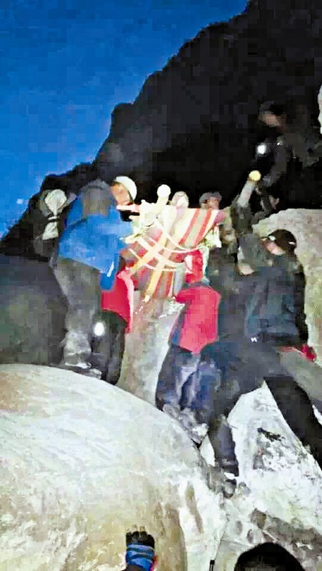 救援隊員用自制的簡易擔(dān)架抬傷者。