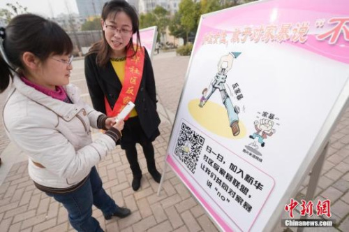 資料圖：今年3月8日，安徽合肥新華社區(qū)志愿者夏一瓊(右)向市民普及反家暴相關(guān)法律知識。鐘欣 攝