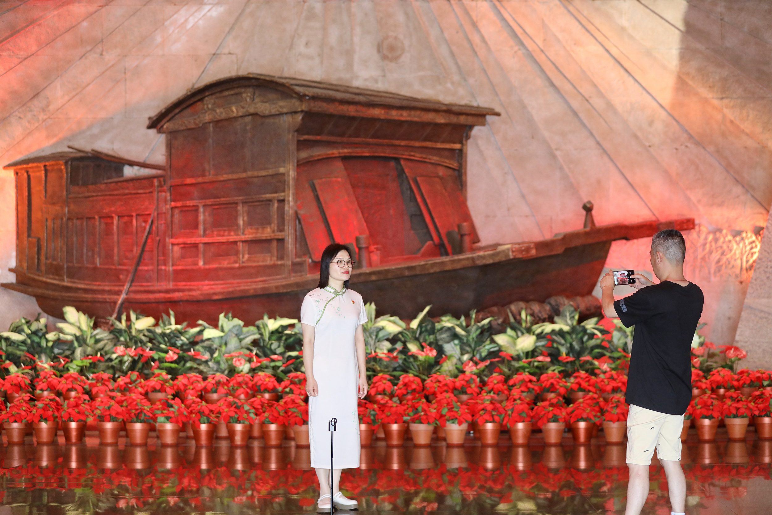 2025年6月24日，浙江嘉興，游客在南湖革命紀念館與紅船雕塑合影。（圖片來源：視覺中國）